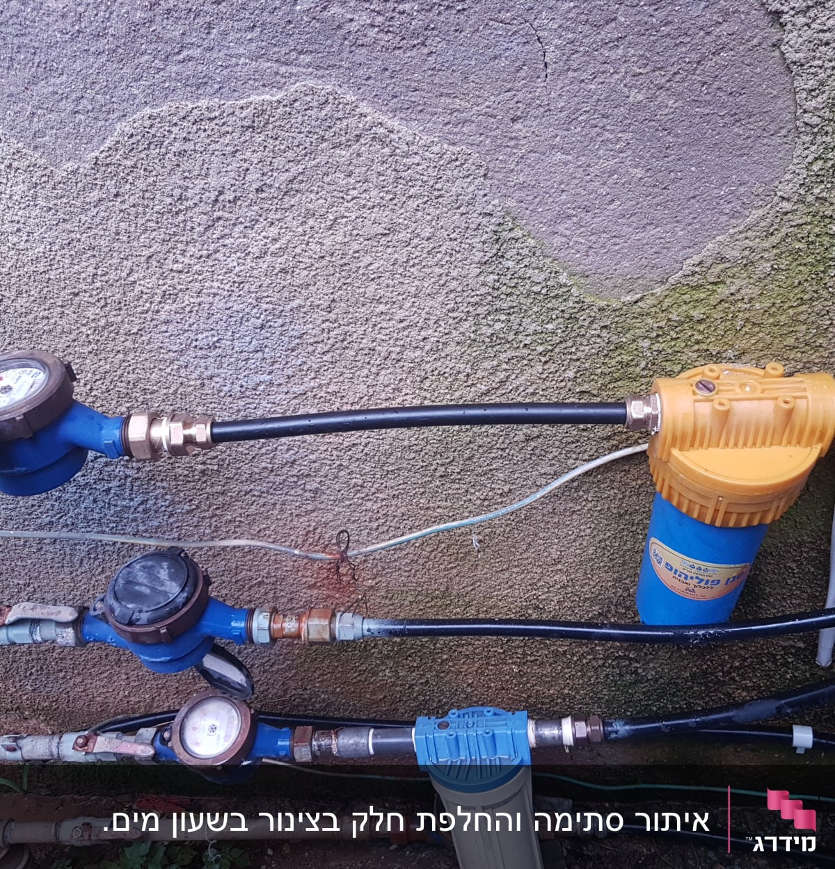 מד מים, צינורות ומסנן מים על קיר